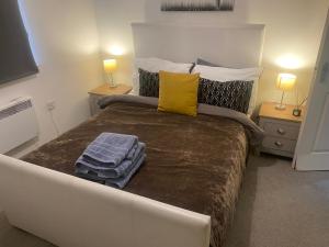 a bedroom with a large bed with towels on it at Sedgefield luxury Apartments. in Sedgefield