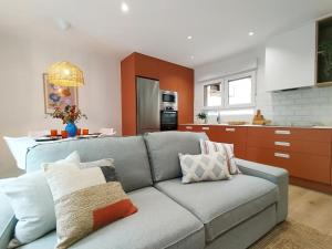 a living room with a couch and a kitchen at Apartamento junto a Ayuntamiento y Playa in Gijón