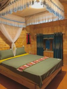 a bedroom with a bed with a canopy and curtains at Lý Tà Quân Homestay in Ha Giang