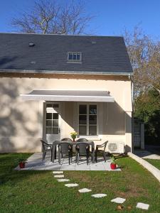 een patio met zwarte tafels en stoelen voor een huis bij Gîte VILLA ESPERANZA (2-6 personnes) in Valençay