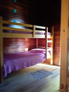 een slaapkamer met een stapelbed in een houten hut bij PINAR DEL SOL I y II in La Paloma