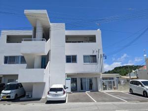um edifício branco com carros estacionados em frente em Guest room WES - Vacation STAY 49860v em Uruma