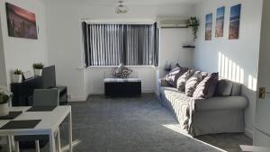a living room with a couch and a table at Seaside 2 bed flat sleeps 6 in Lee-on-the-Solent