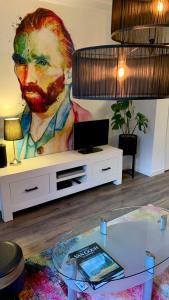 a living room with a painting of a man on the wall at Cityhouse Vincent in Den Helder