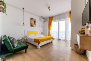 a bedroom with a bed and a green chair at SOLMAR Studios in Năvodari +44 photos