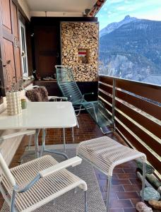 a balcony with a table and chairs and mountains at Sonnige Panorama Aussicht bei Davos Lenzerheide in Schmitten