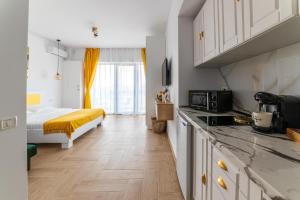 a bedroom with a bed and a kitchen with a counter at SOLMAR Studios in Năvodari
