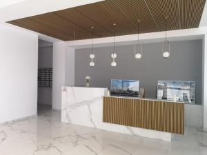a lobby with a reception desk and pendant lights at SOLMAR Studios in Năvodari
