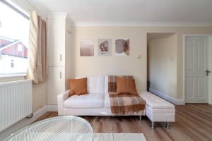 a living room with a white couch and a chair at Lovely Studio Flat in Wimbledon w/ Free Parking in London