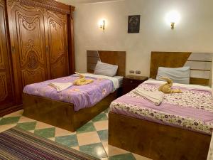 Dos camas en una habitación con cisnes. en PORTO HILL en Hurghada