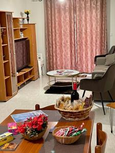 un soggiorno con tavolo e due cestini sopra di Regent Court - 3 bedroom apartment within walking distance from Bugibba seafront a San Pawl il-Baħar
