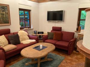 un soggiorno con divani rossi e tavolino da caffè di Haus am Wald a Rudolstadt