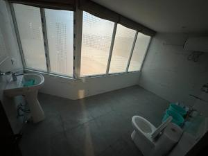 ein Bad mit einem Waschbecken, einem WC und einem Fenster in der Unterkunft Ott Homes in Guwahati