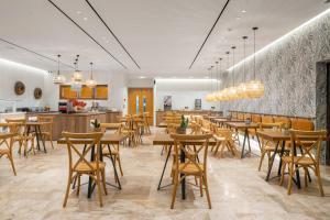 a restaurant with wooden tables and chairs and a counter at Hotel Papillon in Argassi