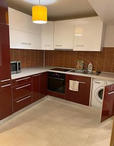 cocina con armarios blancos y lavavajillas en DMT Apartament Rin Grand en Bucarest