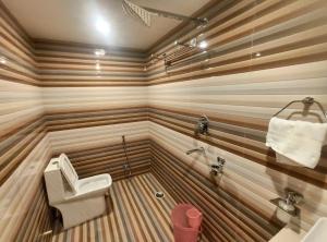 a wooden bathroom with a toilet and a sink at Royal View Residency in Bodh Gaya