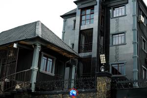 een zwart gebouw met een zwart dak en zwarte ramen bij JEVENOM HOTEL in Ibafo +10 foto's