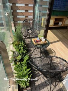 un balcone con 2 sedie, un tavolo e piante di Mây Homestay Ecopark a HÆ°ng YÃªn