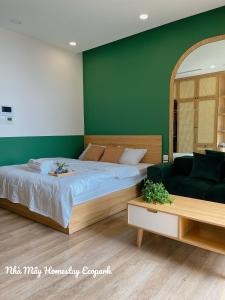 una camera con letto e parete verde di Mây Homestay Ecopark a HÆ°ng YÃªn