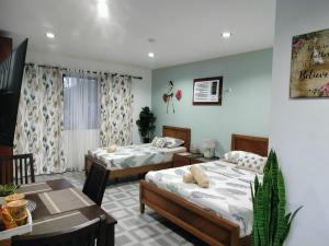 een kamer met 2 bedden, een tafel en een eetkamer bij Seaview Residence Garden 