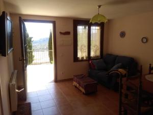 sala de estar con sofá y puerta corredera de cristal en Casa rural El Cestero, en Castellote