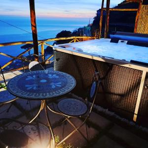 balcón con bañera de hidromasaje y mesa y sillas. en LA CASA DEL CAPITANO furore amalfi coast, en Furore