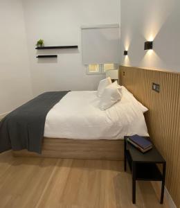 - une chambre avec un lit et une table avec une table de chevet dans l'établissement Auditorio/Bernabéu Apartment1, à Madrid