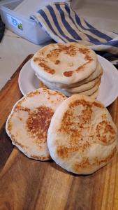 three pancakes on white plates on a wooden table at Ban Lom Jen Homestay in Chiang Rai