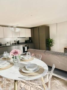 a dining room with a white table and chairs at Spacious 2BR Apartment with Terrance in London