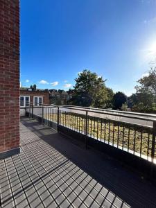 a walkway with a fence next to a building at Spacious 2BR Apartment with Terrance in London