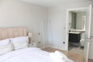 Habitación blanca con cama y baño. en Spacious 2BR Apartment with Terrance, en Londres