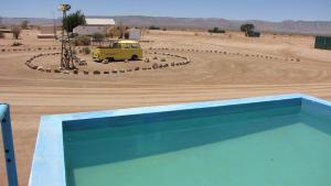 a yellow van parked in the middle of a desert at Canyon Farmyard Camping in Keetmanshoop