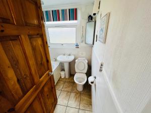 a small bathroom with a toilet and a sink at 2 Bedroom Chalet SB11, Sandown Bay, Dog Friendly in Sandown +7 photos