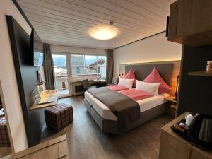 ein Hotelzimmer mit einem Bett und einem Fenster in der Unterkunft Ferienhotel Silberdistel garni in Bolsterlang