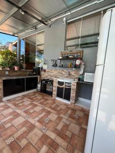 an outdoor kitchen with a tile floor in a kitchen at Hostel Sossego do Garças in Barra do Garças