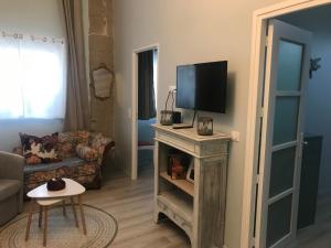 een woonkamer met een tv op een tafel bij L'Apothicaire - BedinShop in Romans-sur-Isère