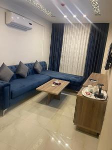 a living room with a blue couch and a table at Antalya Hotel Amman in Amman