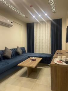 a living room with a blue couch and a table at Antalya Hotel Amman in Amman