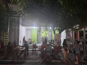 a group of people sitting at tables under a tree at Pousada Point da Nanda in Juazeiro do Norte