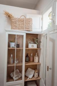 un armario blanco con cestas encima. en La Buena Sombra en Alicante