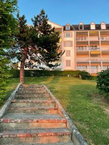 eine Treppe, die zu einem Gebäude mit einem Baum führt in der Unterkunft Le bruit des vagues à Trouville sur mer in Trouville-sur-Mer