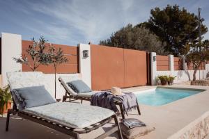 Un patio con dos sillas y una piscina. en La Buena Sombra, en Alicante