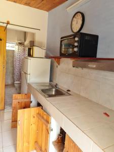 DaWy في Areguá: مطبخ مع حوض وساعة على الحائط