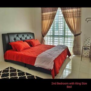 een slaapkamer met een rood bed en een groot raam bij Damai Homestay Alor Setar in Alor Setar