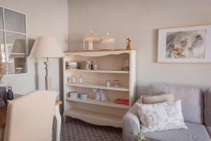 Una sala de estar con un sofá y un estante con platos. en La Buena Sombra, en Alicante