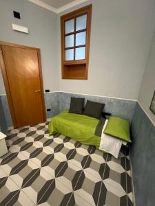 a bedroom with a green bed with a checkered floor at Bell'e Buono vicino aeroporto di Capodichino in Naples