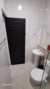 a white bathroom with a toilet and a sink at Apartamento top central in Pau dos Ferros