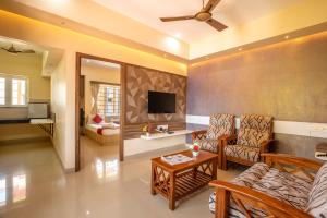 a living room with a couch and a tv at MK Residency in Coimbatore
