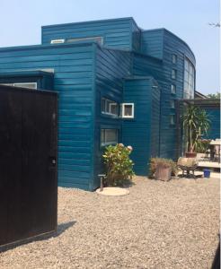 una casa azul con una puerta negra delante de ella en Casa isla Negra, en Isla Negra