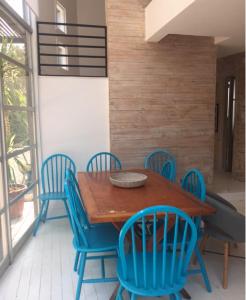 una mesa de madera con sillas azules alrededor en Casa isla Negra, en Isla Negra